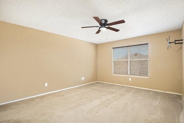 spare room with ceiling fan, light colored carpet, and a textured ceiling