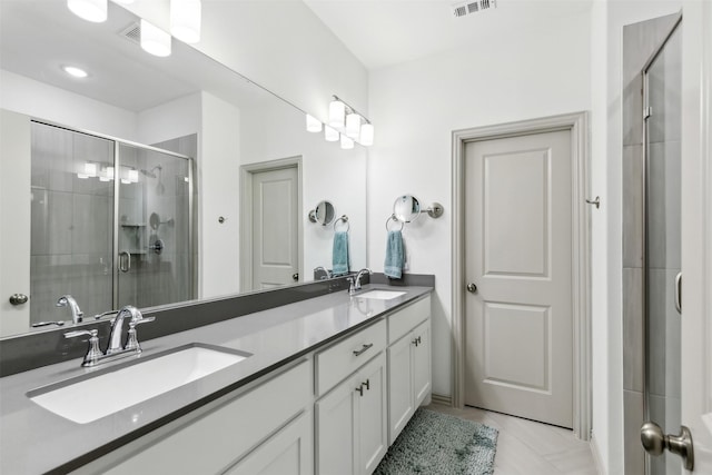 bathroom featuring a shower with shower door, tile patterned floors, and vanity