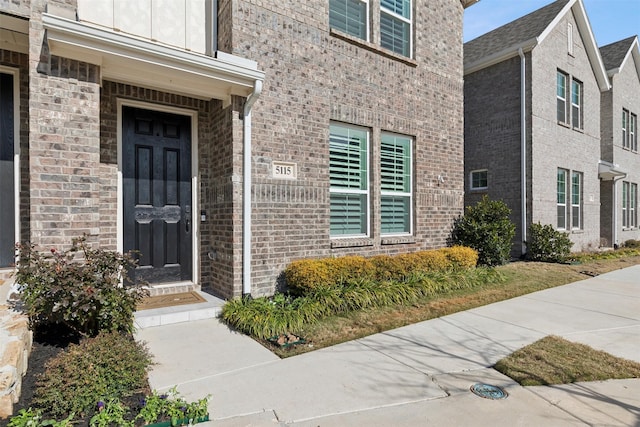 view of exterior entry with brick siding