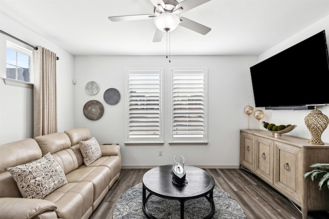 living room with baseboards, dark wood-style flooring, and ceiling fan