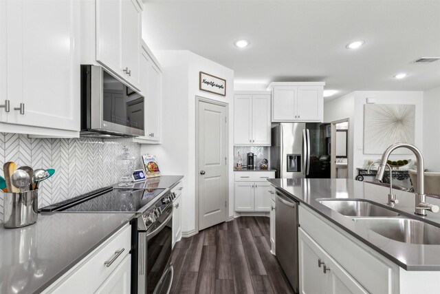 kitchen featuring stainless steel appliances, tasteful backsplash, dark hardwood / wood-style flooring, white cabinets, and sink