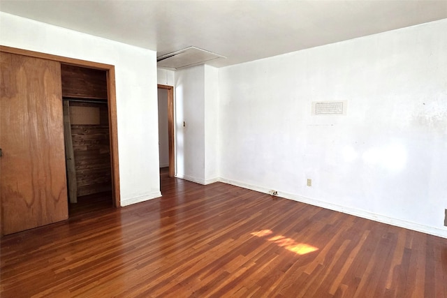 unfurnished bedroom featuring dark wood-type flooring and a closet