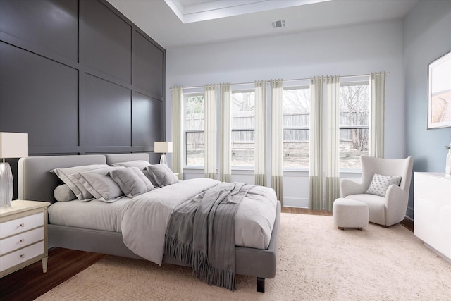 bedroom with multiple windows and light wood-style floors