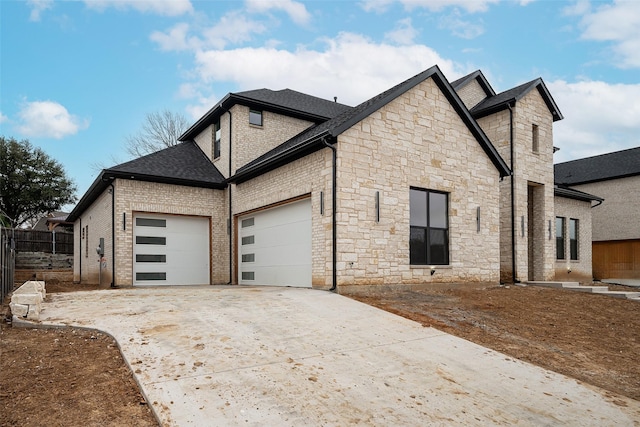 view of side of property featuring brick siding, roof with shingles, a garage, stone siding, and driveway