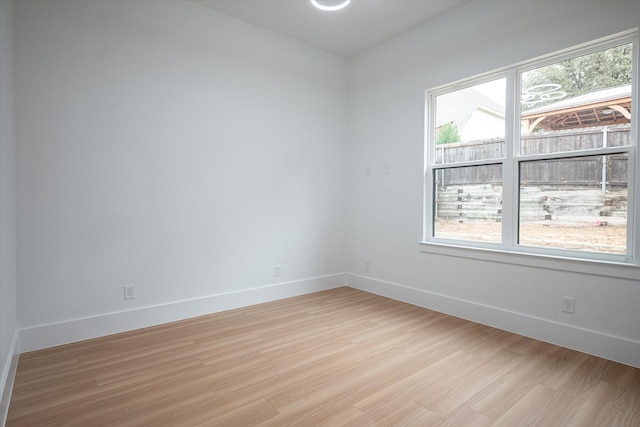 spare room with light wood finished floors and baseboards