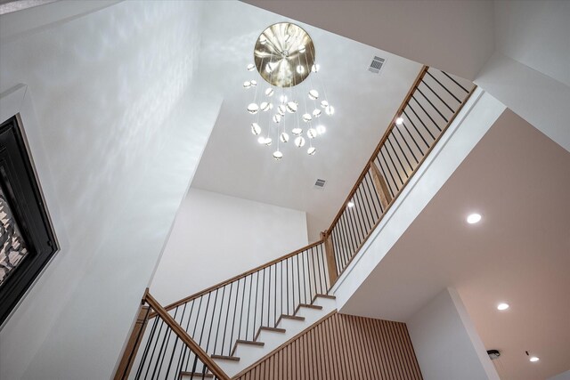 stairs featuring a towering ceiling and recessed lighting