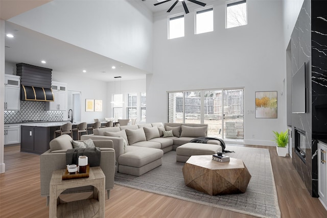 living room featuring a wealth of natural light, recessed lighting, ceiling fan, and wood finished floors