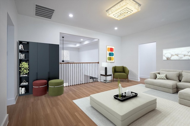 living room featuring wood finished floors, recessed lighting, and baseboards