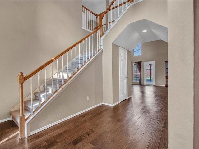 staircase featuring hardwood / wood-style floors and a high ceiling