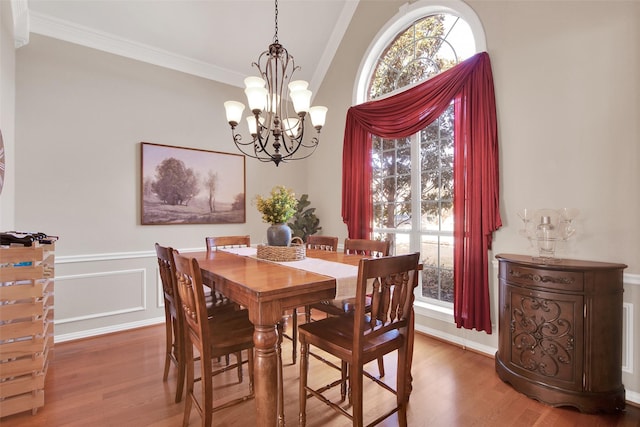 dining area with wood-type flooring, a chandelier, and crown molding