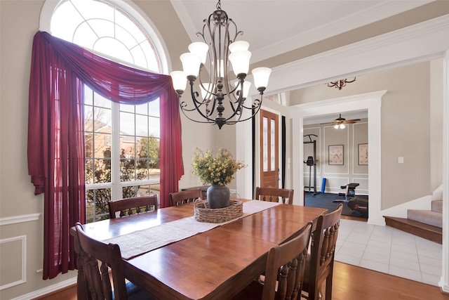 dining room featuring ornamental molding, wood finished floors, ceiling fan, and stairs