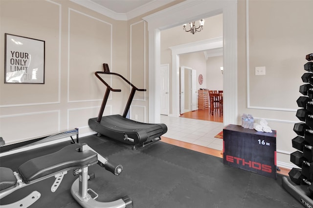 exercise room featuring hardwood / wood-style flooring, crown molding, and a chandelier