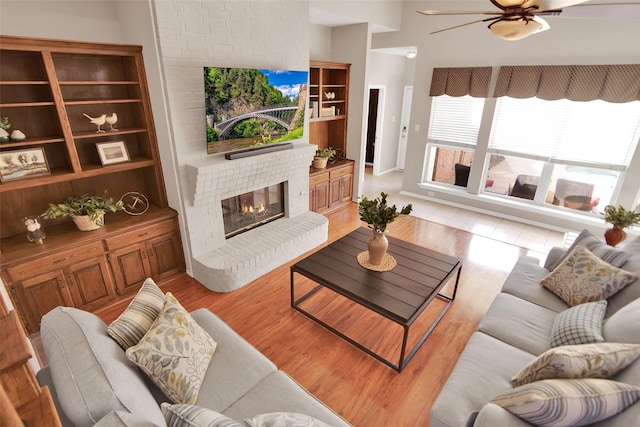 living room featuring light wood finished floors and a brick fireplace