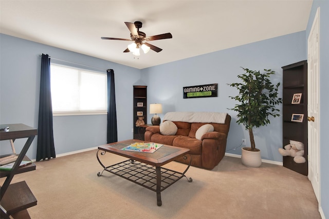 living area with ceiling fan, carpet, and baseboards