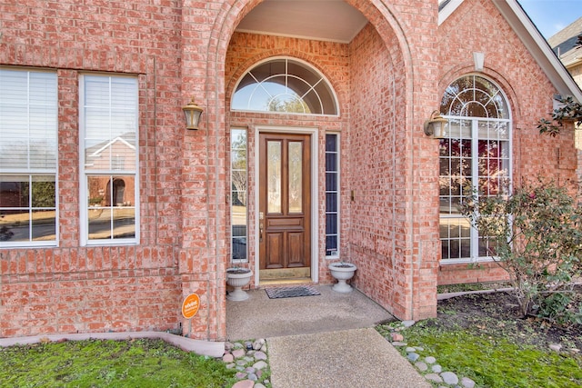 doorway to property with brick siding