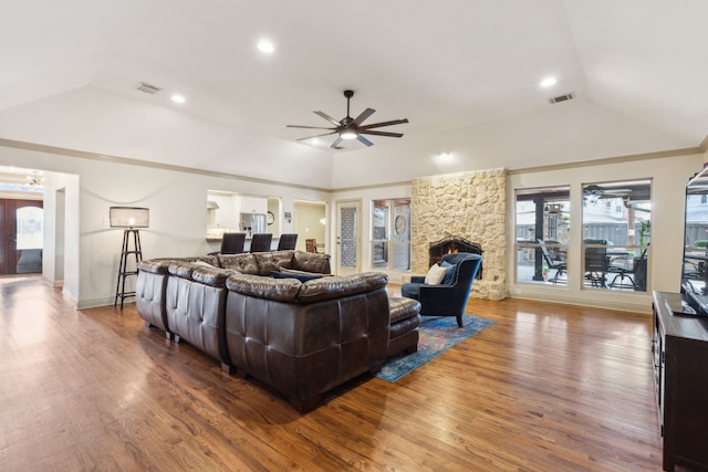 living room featuring wood-type flooring, a fireplace, ceiling fan, and vaulted ceiling