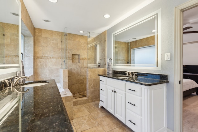 bathroom with a tile shower and vanity