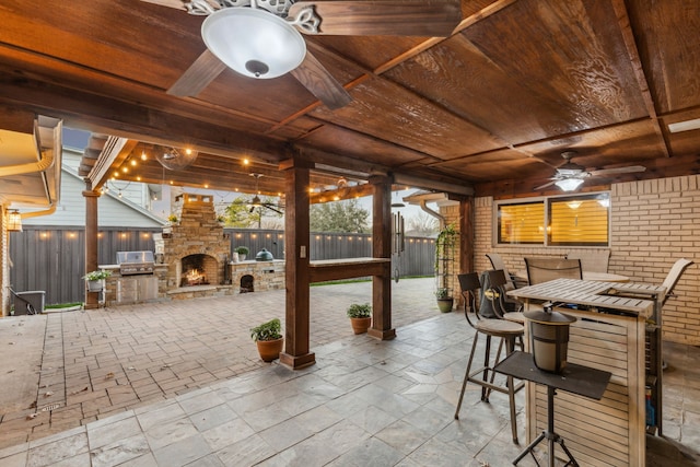 view of patio featuring a grill, ceiling fan, and an outdoor stone fireplace