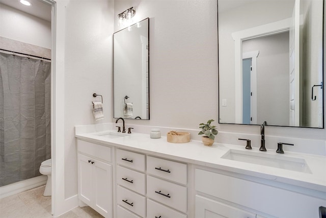 bathroom with double vanity, a sink, toilet, and a shower with curtain