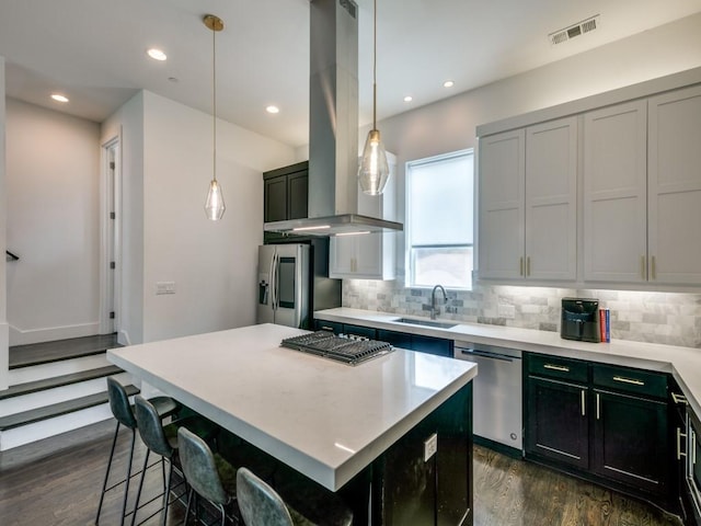 kitchen with decorative light fixtures, stainless steel appliances, island exhaust hood, and a center island