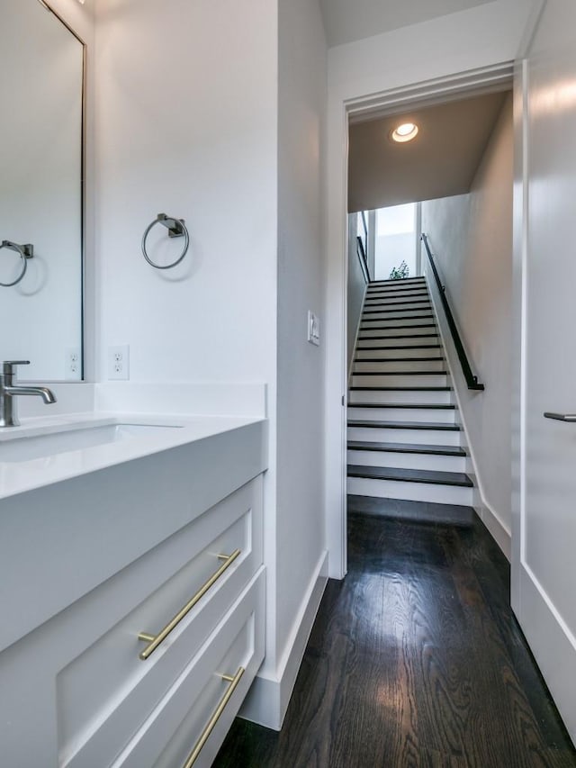 stairs featuring sink and hardwood / wood-style floors