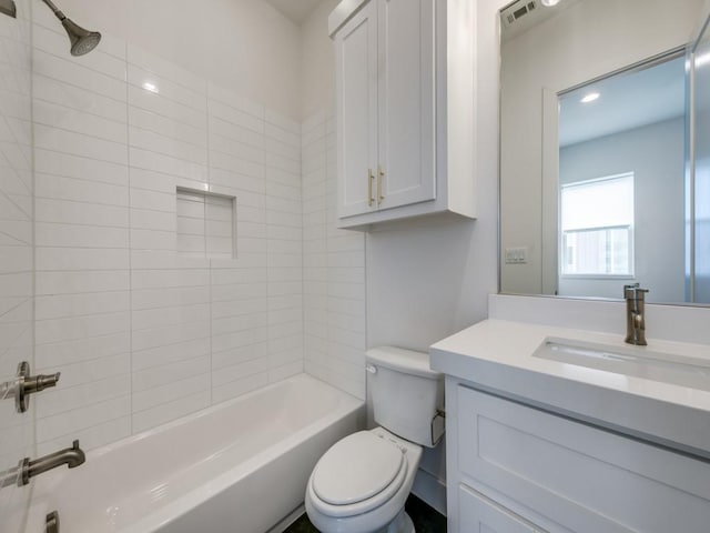 full bathroom featuring toilet, vanity, and tiled shower / bath