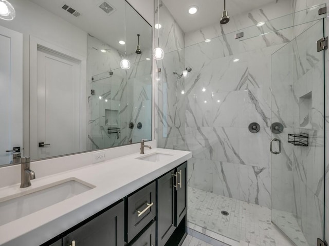 bathroom with a shower with door and vanity