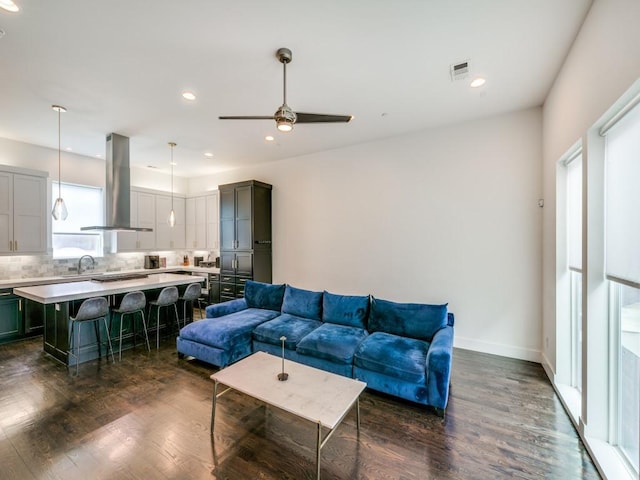 living room featuring ceiling fan and dark wood-type flooring