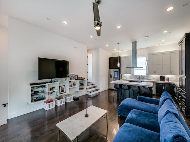 living room featuring sink, dark hardwood / wood-style flooring, and ceiling fan