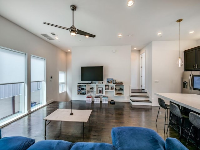 living room featuring ceiling fan and dark hardwood / wood-style floors