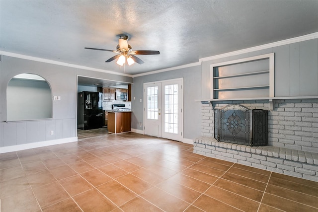 unfurnished living room with built in shelves, a brick fireplace, ceiling fan, light tile patterned floors, and crown molding