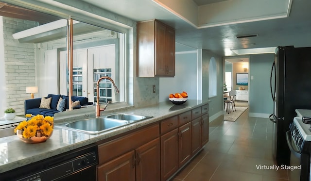 kitchen with black dishwasher, a healthy amount of sunlight, gas stove, fridge, and sink