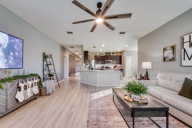 living room with light wood-type flooring and ceiling fan