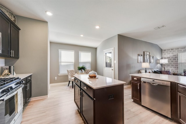 kitchen featuring lofted ceiling, appliances with stainless steel finishes, light hardwood / wood-style flooring, and a center island