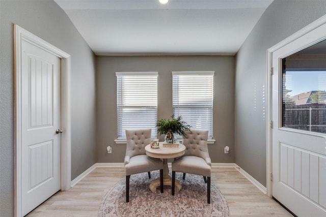 dining room featuring light wood-type flooring and vaulted ceiling