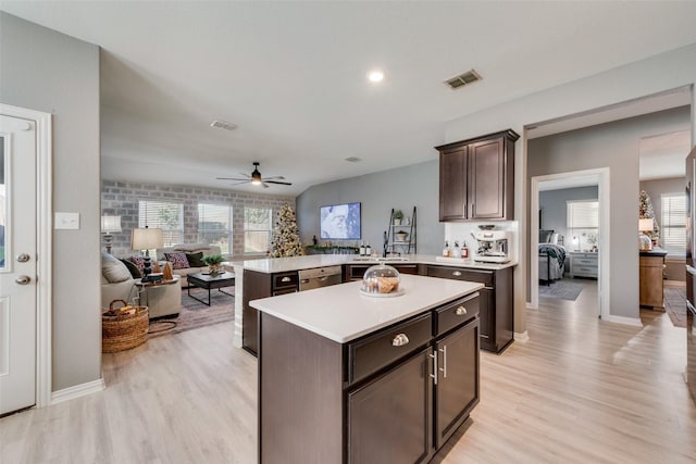 kitchen featuring kitchen peninsula, stainless steel dishwasher, a wealth of natural light, light wood-type flooring, and ceiling fan