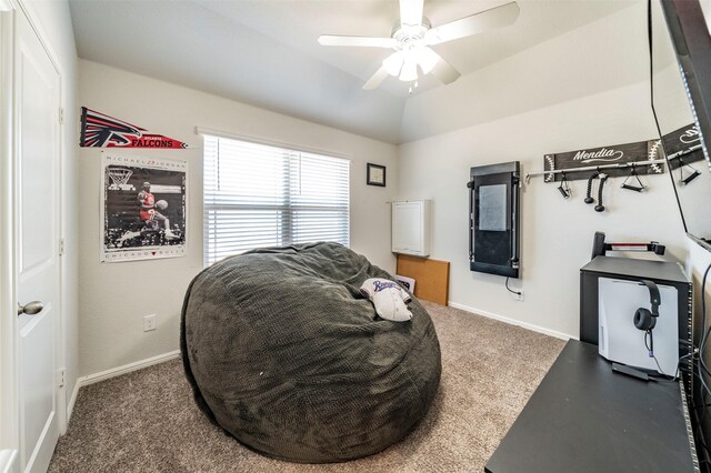 living area with lofted ceiling, dark colored carpet, and ceiling fan