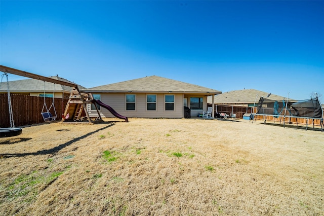 back of property with a playground and a trampoline