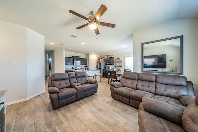 living room with lofted ceiling, light wood-type flooring, and ceiling fan