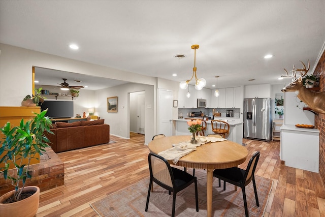 dining area featuring ceiling fan and light wood-type flooring