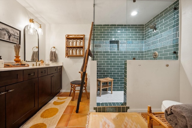 bathroom with tile patterned floors, tiled shower, and vanity