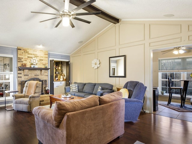 living room featuring a brick fireplace, ceiling fan, dark hardwood / wood-style flooring, a textured ceiling, and lofted ceiling with beams