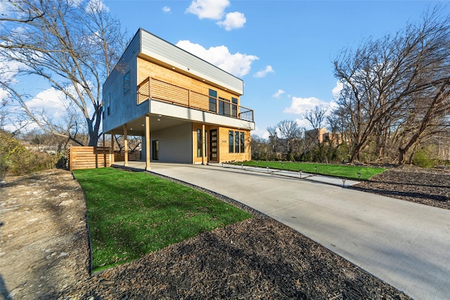 modern home with a balcony and a front lawn