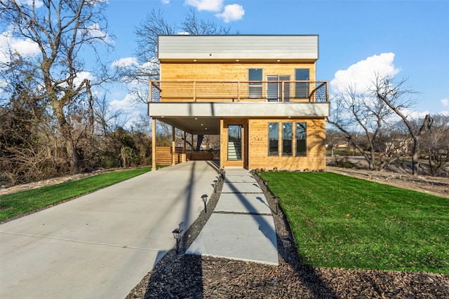 contemporary home featuring a carport, a balcony, and a front lawn