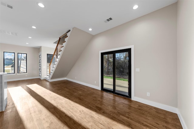 unfurnished living room featuring dark hardwood / wood-style flooring and plenty of natural light