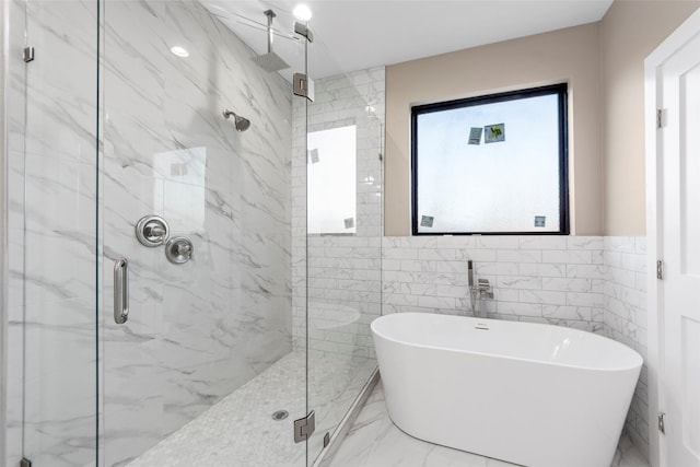 bathroom with tile walls and shower with separate bathtub