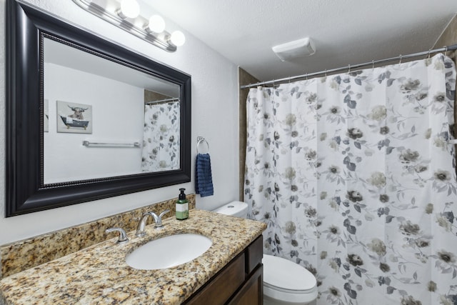 bathroom featuring a textured ceiling, a shower with shower curtain, vanity, and toilet