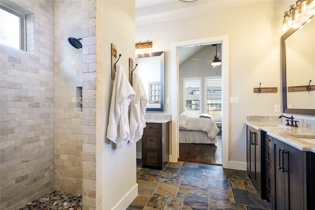 bathroom with vanity, lofted ceiling, ceiling fan, and a tile shower