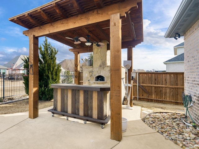 view of patio featuring an outdoor stone fireplace and ceiling fan