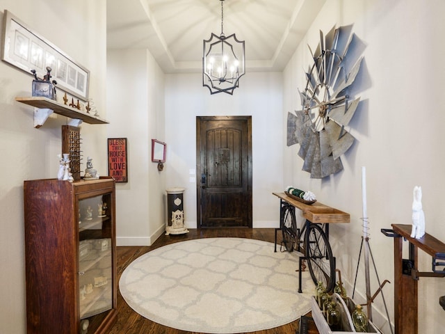 foyer entrance with a chandelier, dark hardwood / wood-style floors, and a raised ceiling